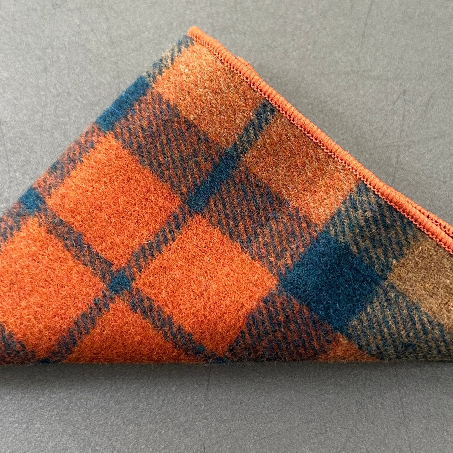 An orange checked wool pocket square for men ideal as a mens and groomsmen gift or as an EDC hank.