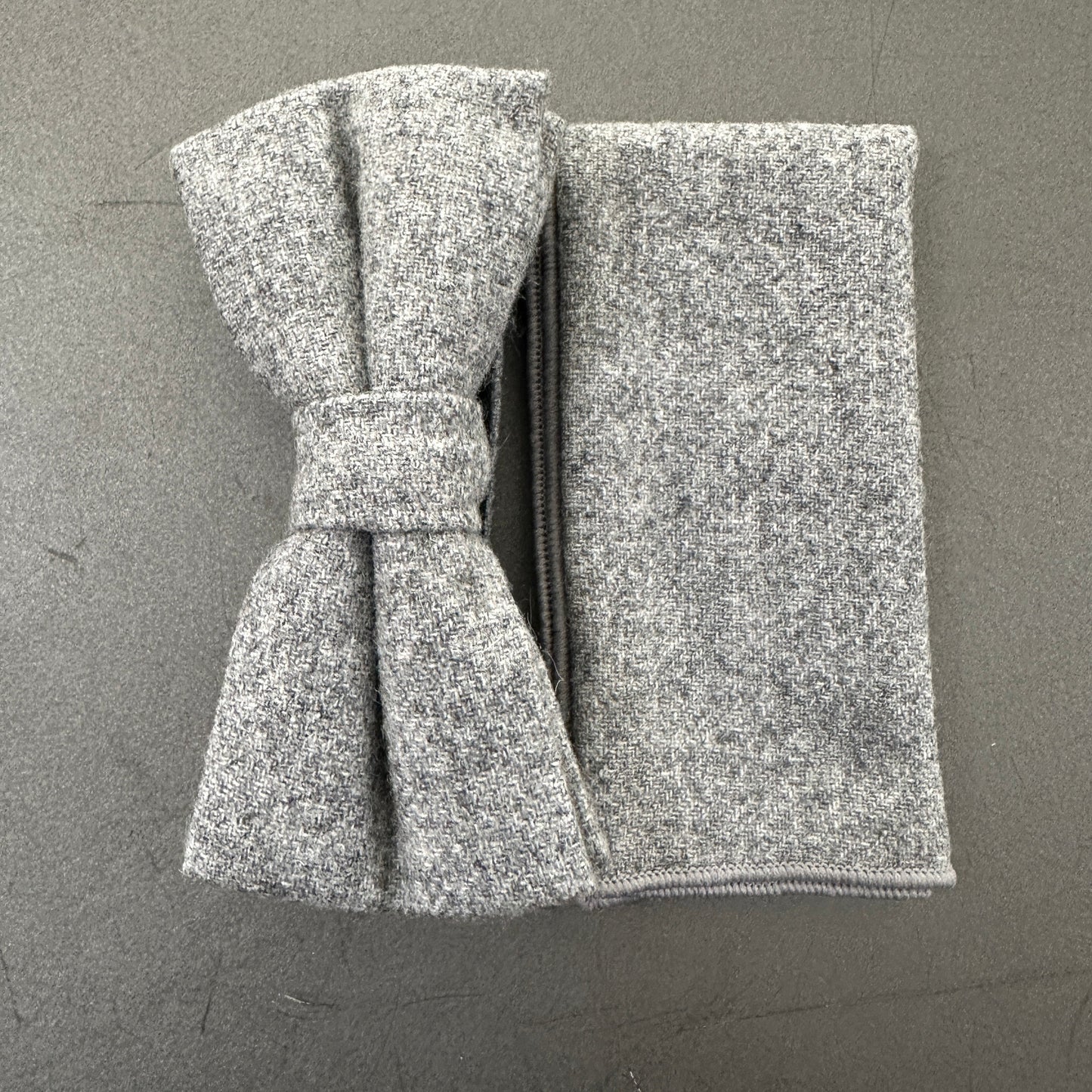 A grey wool bow tie and pocket square set for men. Ideal wedding attire.