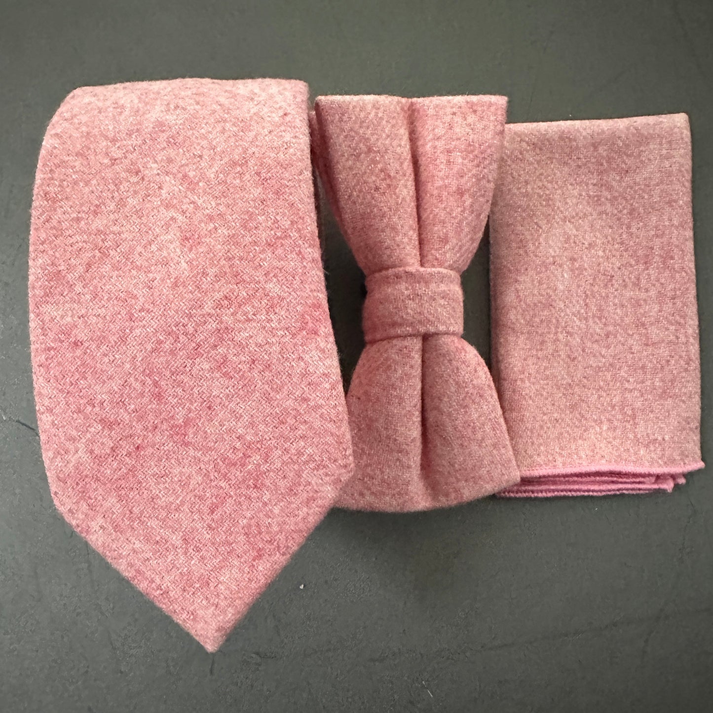 A pink tie bow tie and pocket square set in blush pink wool for grooms and groomsmen.
