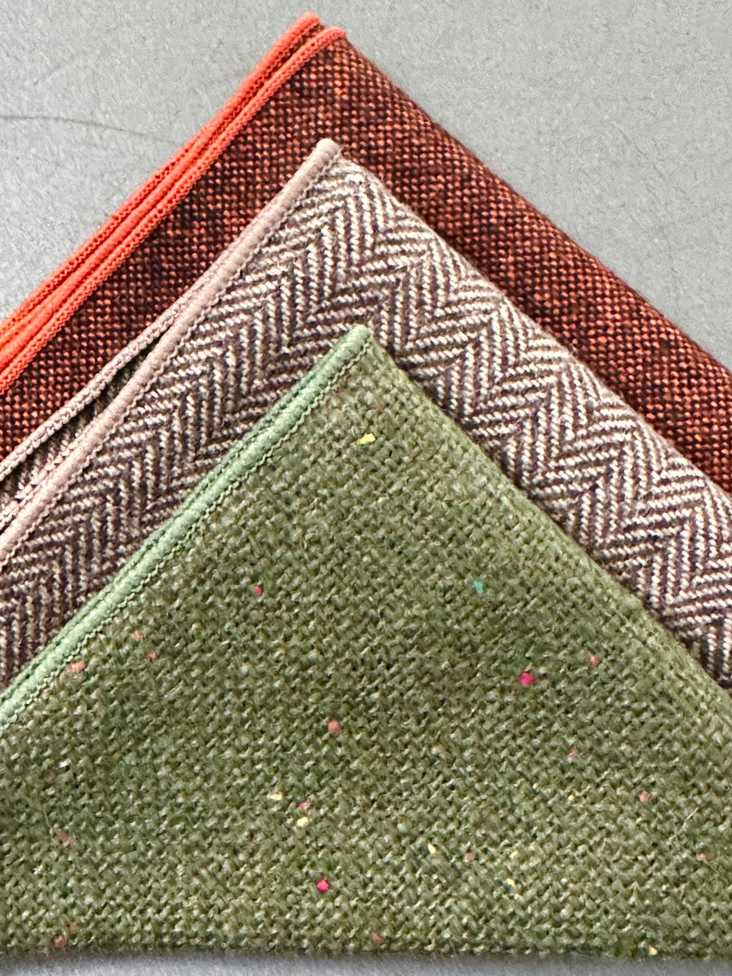 A set of three mens hankies in wool. THe set is in burnt orange, green and brown herringbone and make ideal mens handkerchief gifts, groomsmen gifts and EDC hanks for revery day carry.