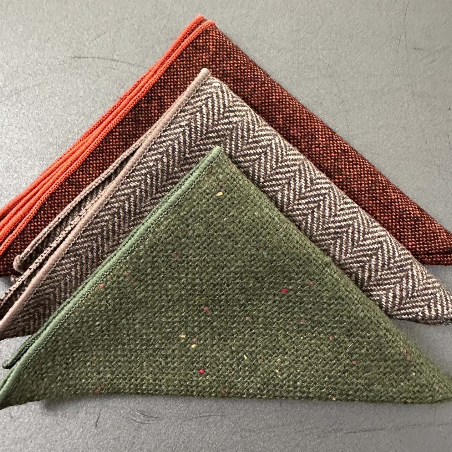 A set of three mens hankies in wool. THe set is in burnt orange, green and brown herringbone and make ideal mens hanky gifts, groomsmen gifts and EDC hanks for revery day carry.