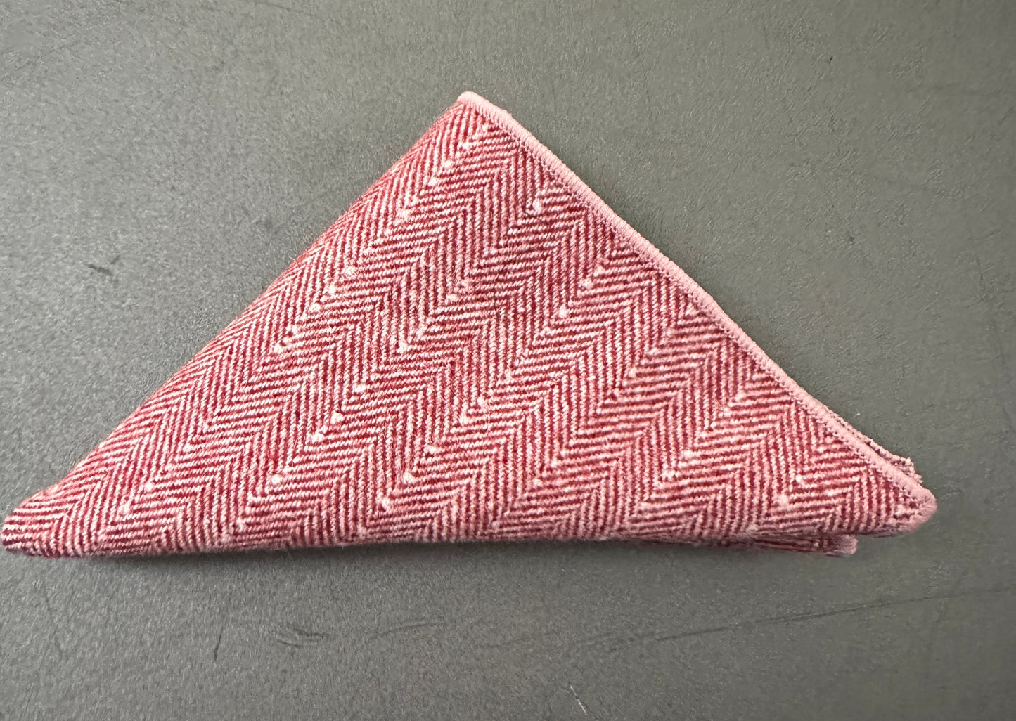 A pink pocket square in a set of three unisex pocket squares in red, cream and pink herringbone wool. Ideal as EDC hanks and as gifts. The set comes with free gift wrap.