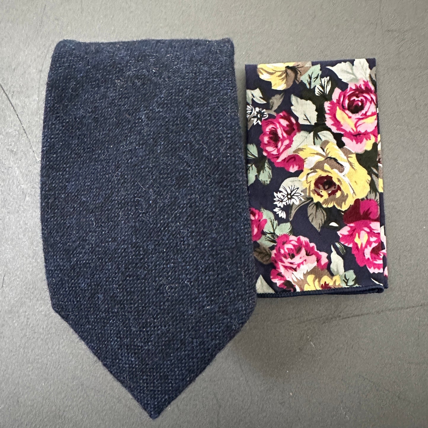 A navy blue mens wool tie and floral pocket square ideal for weddings and wedding guest attire.