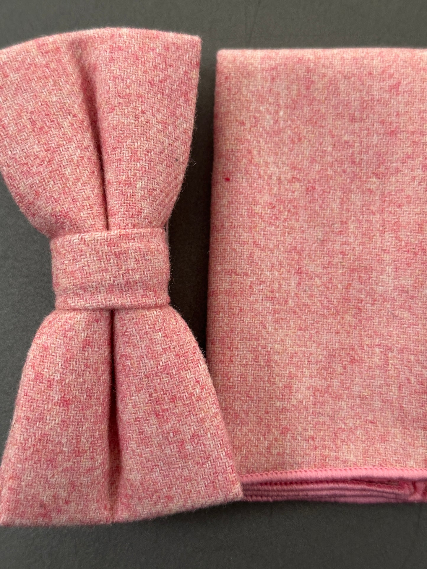 A pink bow tie and pocket square set in blush pink wool for grooms and groomsmen. Ideal for carnation themed weddings.