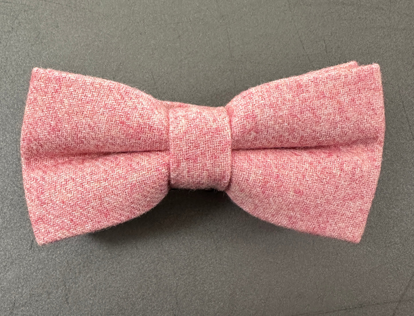 A pink bow tie in blush pink wool for grooms and groomsmen.