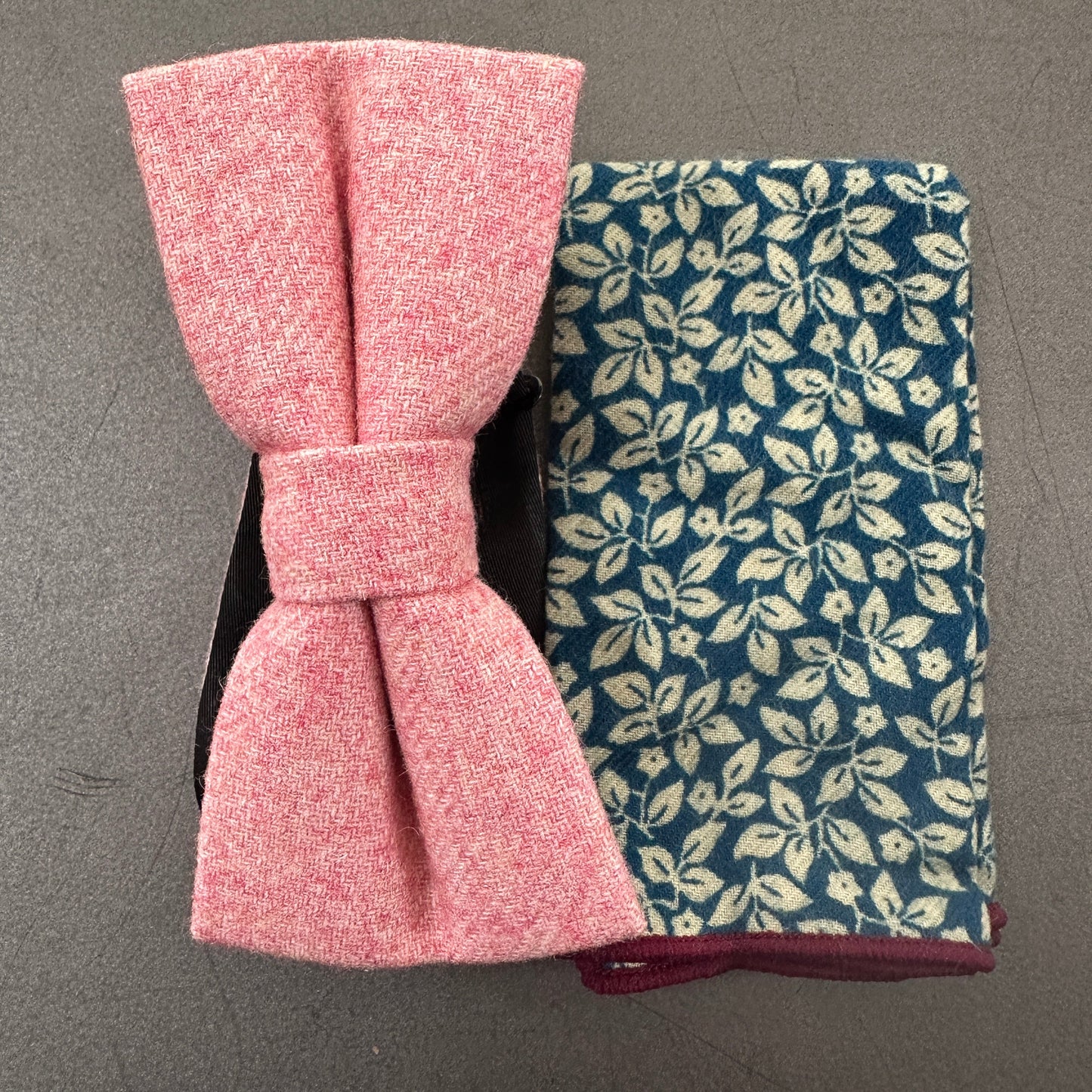 A blush pink mens bow tie matched with a blue floral pocket square for wedding ties.