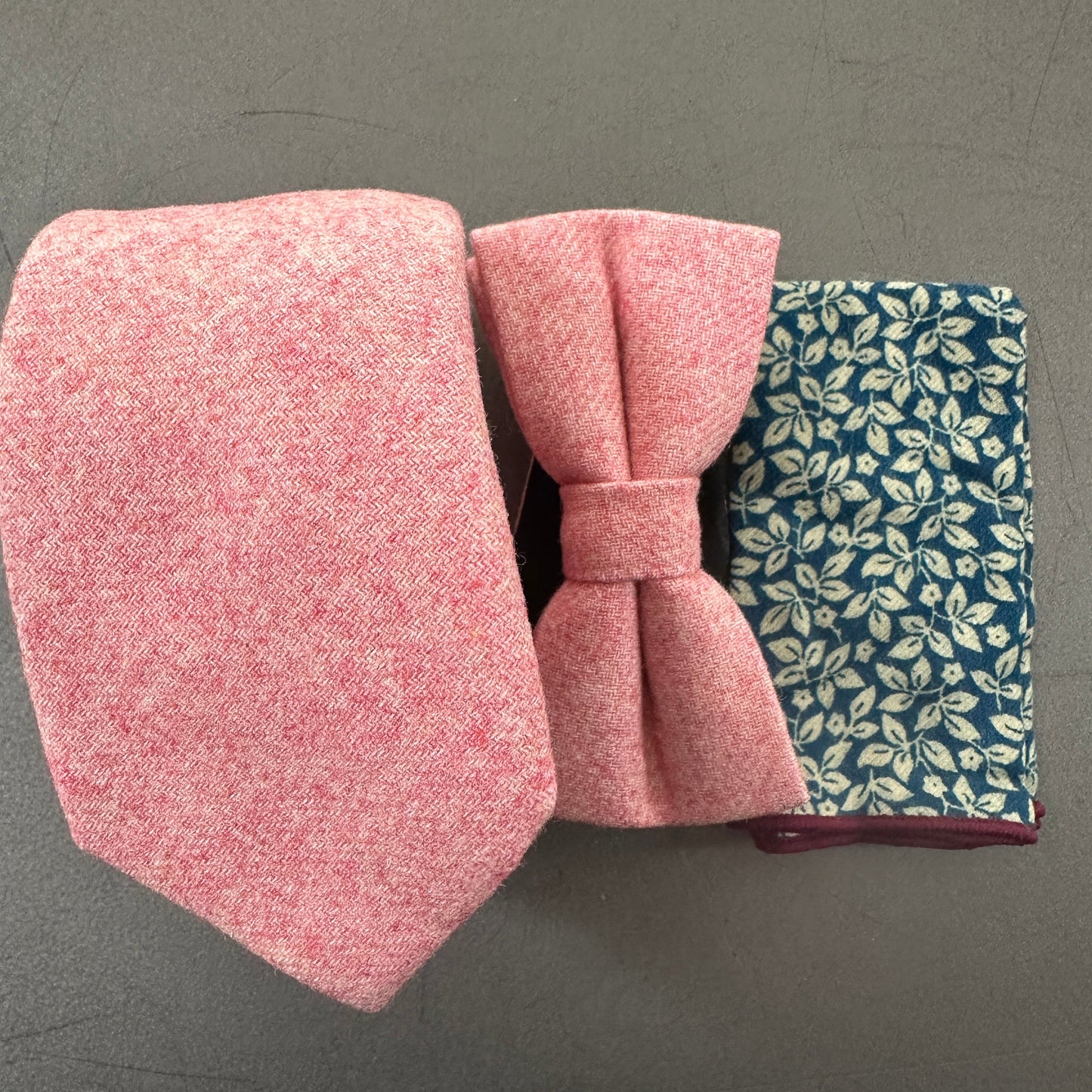 A blush pink mens tie and bow tie ideal for weddings. The set comes with a blue floral pocket square .