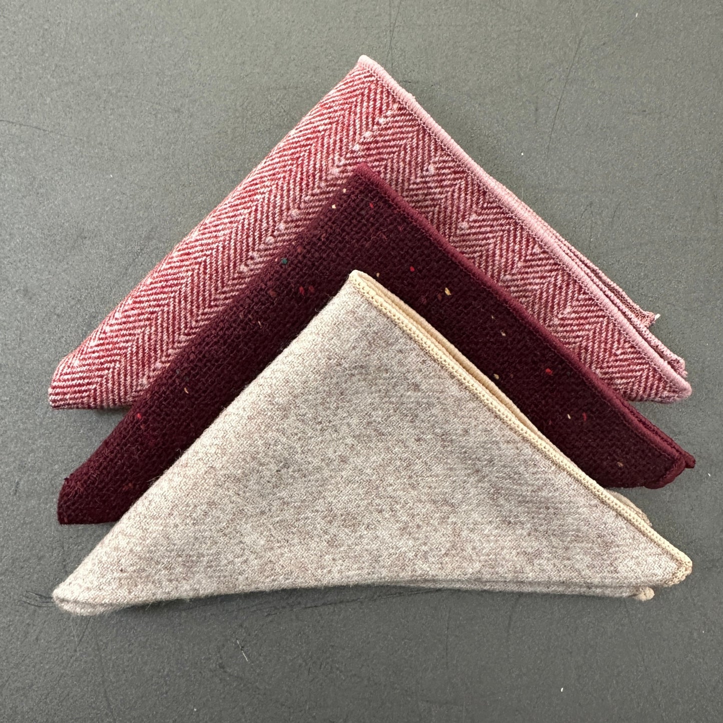 A set of three unisex pocket squares in red, cream and pink herringbone wool. Ideal as EDC hanks and as gifts. The set comes with free gift wrap.