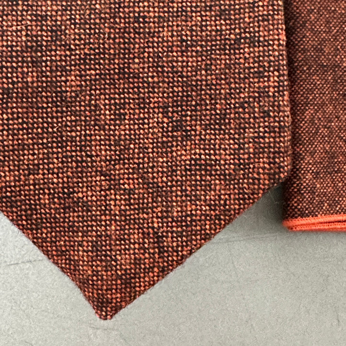 A burnt orange tie and pocket square for grooms and groomsmen.
