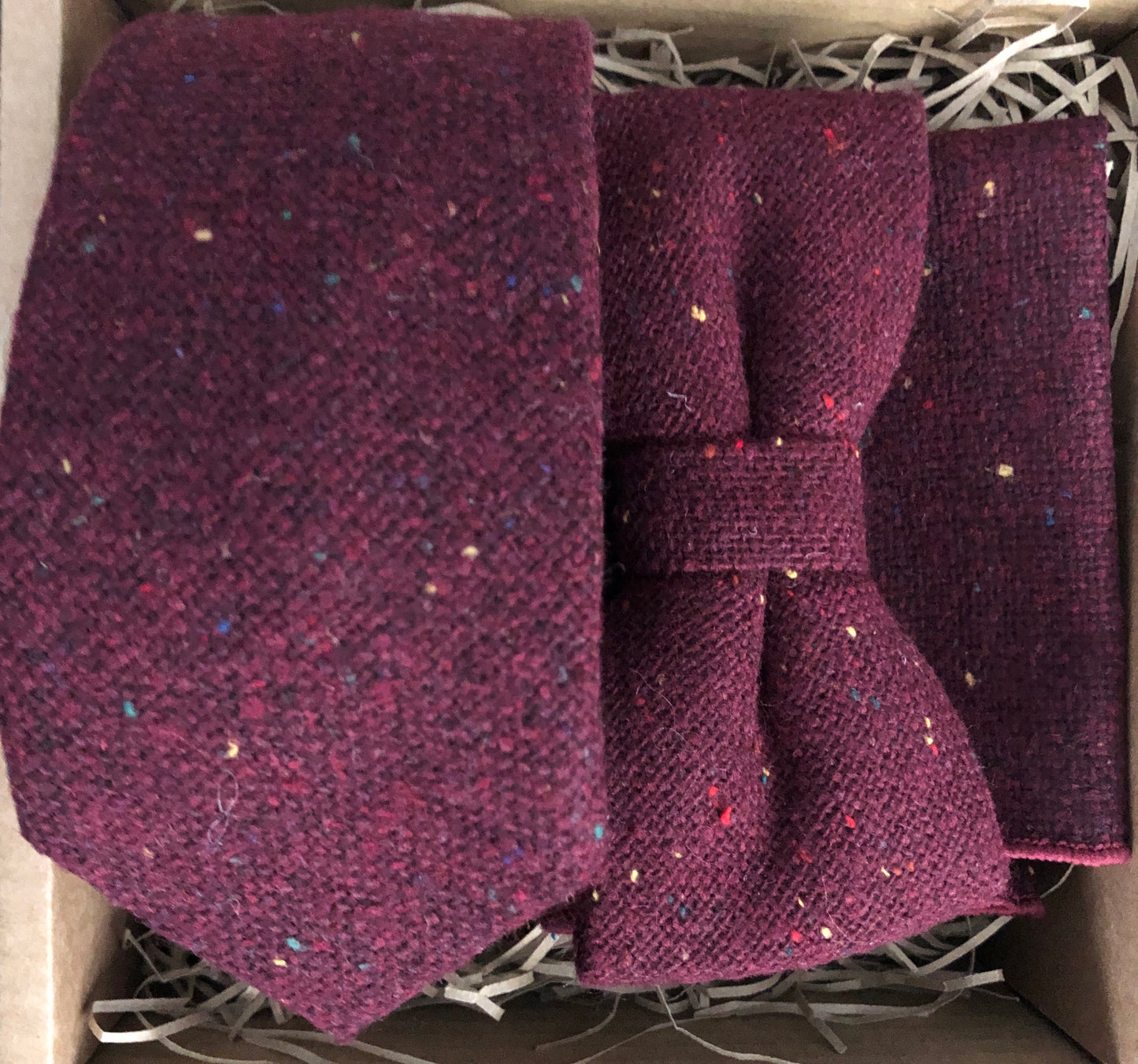 A deep red burgunday flecked wool tie, bow tie and pocket square. The set is gift wrapped and makes a fabulous men's Christmas gift or groomsmen gifts at a wedding. BY Daisy and oak Studio.