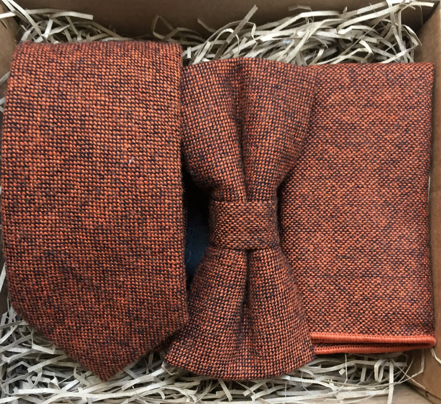 A burnt orange wool mens tie, bow tie and pocket square in a flecked wool fabric. The set makes an ideal mens gift and comes with free shipping and gift wrapping. Handmade by Daisy and Oak Studio