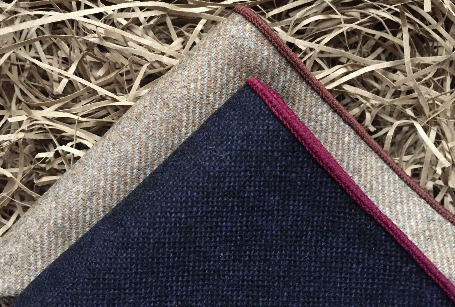 A set of two men's pocket square handkerchiefs in wool. The set has one navy handkerchief with red trim and one beige one. The set is made by hand at Daisy and Oak Studio. The set is beautifully gift wrapped and makes an ideal men's gift fo Christmas.