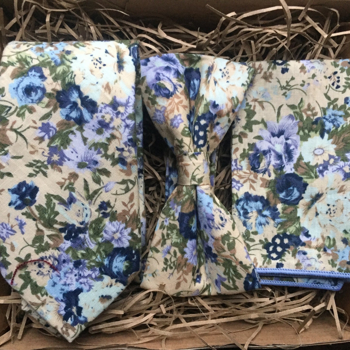 A men's bue floral tie, bow tie and pocket square set ideal for weddings and as men gifts. The set comes with free gift wrapping and is made at Daisy and Oak Studios, UK
