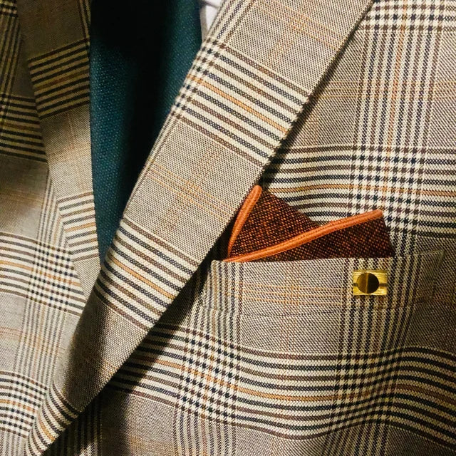 A burnt orange wool men's tie and pocket square. The tie is a flecked wool rust colour and the pocket square is in a floral orange cotton. The set comes with free gift wrapping and is handmade by Daisy and Oak Studio, UK