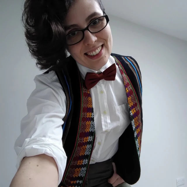 A woman wearing a flecked red woo bow tie. This is an ideal gift as it is gift wrapped and handmade by Daisy and Oak Studio.