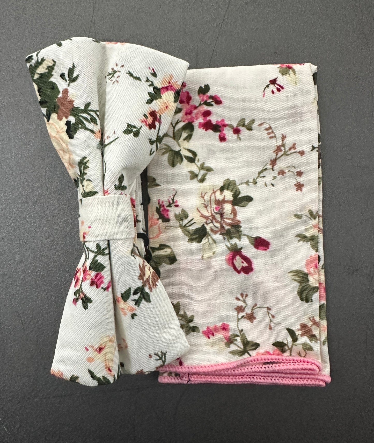 A blush pink rose bow tie and pocket square set for weddings. The set is made in cotton and is on a cream background.