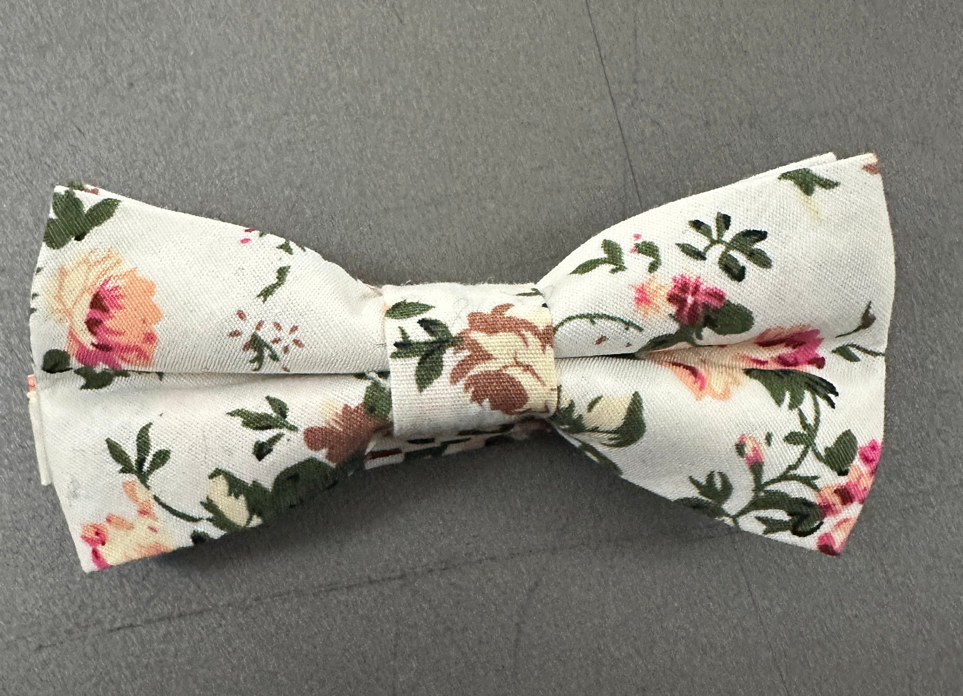 A blush pink rose. bow tie for weddings. The set is made in cotton and is on a cream background.