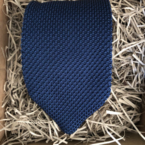 A navy knitted necktie suitable for all occasions. The necktie is wrapped in a gift box with a gift tag so is suitable as a men's Christmas gift. Handmade by Daisy and Oak Studio.
