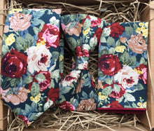 Load image into Gallery viewer, A red cotton tie, bow tie and pocket square set in a floral pattern on a navy background. This set is handmade at the Daisy and Oak Studio, UK 