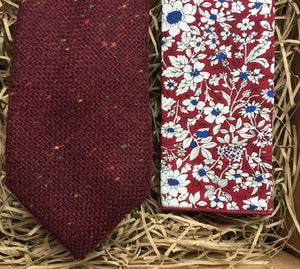 A close up shot of a man's burgundy red flecked wool tie and red floral pocket handkerchief. The set comes gif t wrapped and makes the best Christmas gift for men, grooms gift and groomsmen 's gift.