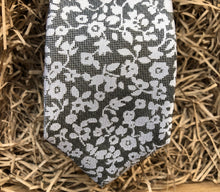 Load image into Gallery viewer, A close up of a silver grey tie with white flowers on a grey background. Ideal as a formal tie, wedding tie or for a special occasion. The tie is made by Daisy and Oak Studio and comes beautifully gift wrapped with free shipping.