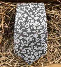 Load image into Gallery viewer, A silver grey tie with white flowers on a grey background. Ideal as a formal tie, wedding tie or for a special occasion. The tie is made by Daisy and Oak Studio and comes beautifully gift wrapped with free shipping.