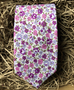 A lavender floral cotton men's tie with purple flowers and green accents. The ties are hand made by Daisy and Oak Studio and come gift wrapped so make ideal men's gifts and grooms and groomsmen ties.