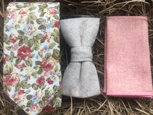 Load image into Gallery viewer, A pink floral men&#39;s tie, cream wool bow tie and  pink wool pocket square. The tie set comes with free gift wrapping and is handmade in the Daisy and Oak Studio, UK