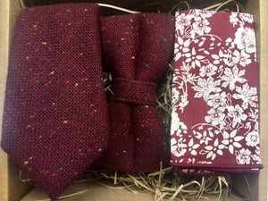 A red, flecked wool tie, bow tie and pocket square set. The tie is burgundy with red, yellow and green flecks. The set comes beautifully gift wrapped and makes an ideal men's gift. The set is made at the Daisy and Oak Studio.
