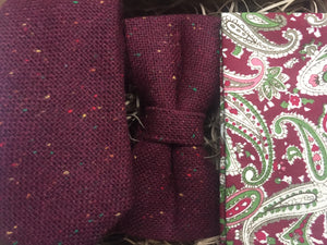 A close up of a deep red men's wool flecked tie, tweed bow tie and red paisley pocket square.The set makes a stunning gift for men, wedding tie or groomsman gift. Handmade by Daisy and Oak Studio.