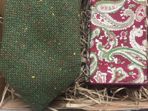 A moss green wool men's tie. The flecks are yellow, red, green. The tie comes with free shipping and gift wrap and is handmade by Daisy and Oak Studio.