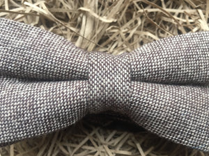 A close up photo of a light brown herringbone tweed bow tie for men. This is a beautiful gift for a men for Christmas or for a groom and his groomsmen at a wedding.