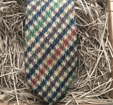 Load image into Gallery viewer, A photo of a mens necktie in a houndstooth pattern. The colours in the tie are green, brown, navy and burnt orange. This is a beautiful necktie and comes gift wrapped and so makes a fabulous men&#39;s gift  or secret Santa. IT is also often used as a wedding tie, groomsmen gift or grooms tie paired with  a tween suit.