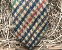 Load image into Gallery viewer, A close up photo of a mens necktie in a houndstooth pattern. The colours in the tie are green, brown, navy and burnt orange. This is a beautiful necktie and comes gift wrapped and so makes a fabulous men&#39;s gift or secret Santa. It is also often used as a wedding tie, groomsmen gift or grooms tie paired with a tween suit.
