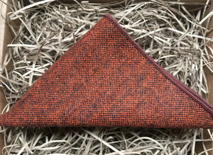 A men's burnt orange wool pocket square worn with a beige checked suit. THe pocket square comes gift wrapped and is handmade by Daisy and Oak Studio.