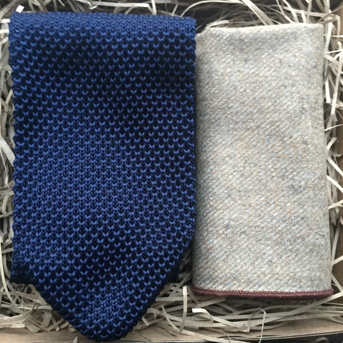 A navy blue men's knitted tie and beige wool pocket square handkerchief. Our ties come with free gift wrapping and make ideal presents for, men, groomsmen and as wedding ties. Daisy and Oak Studio.