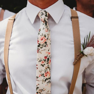 A groom wearing a blush pink floral men's tie and beige braces. Daisy and Oak Studio makes bespoke men's ties, bow ties and pocket squares. All of our products are gift wrapped and make perfect men's gifts at Christmas and birthdays.