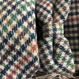 A close up of a herringbone tweed tie, bow tie and pocket square set in checked wool. The colours in the set are brown, green burnt orange and beige. THe set comes gift wrapped and so is perfect as a groomsman gift, men's Christmas gift or secret Santa.
