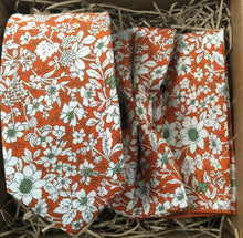 Load image into Gallery viewer, An orange floral tie, bow tie and pocket square ideal for an orange or burnt orange themed wedding. The tie set is handmade by Daisy and Oak Studio.
