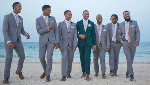 Groomsmen on a beach wearing a blush pink floral men's tie and beige braces. Daisy and Oak Studio makes bespoke men's ties, bow ties and pocket squares. All of our products are gift wrapped and make perfect men's gifts at Christmas and birthdays.