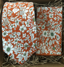 Load image into Gallery viewer, An orange floral tie and pocket quare made in cotton. The tie has  hints of green and is handmade by Daisy and Oak Studio. The tie set comes gift wrapped and is ideal as a mens gift.