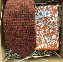 Load image into Gallery viewer, A burnt orange wool men&#39;s tie and pocket square. The tie is a flecked wool rust colour and the pocket square is in a floral orange cotton. The set comes with free gift wrapping and is handmade by Daisy and Oak Studio, UK