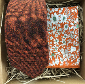 A burnt orange wool men's tie and pocket square. The tie is a flecked wool rust colour and the pocket square is in a floral orange cotton. The set comes with free gift wrapping and is handmade by Daisy and Oak Studio, UK