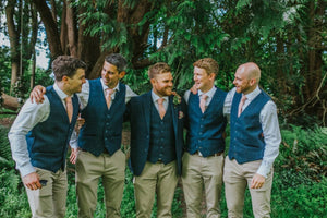 A photo of 5 groomsmen at a wedding wearing a blush pink tie, bow tie and pocket square by Daisy and Oak Studio. The tie is made of wool and comes beautifully gift wrapped so is perfect for men's gifts, wedding ties and groomsmen's gifts.