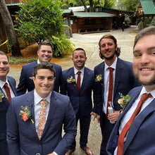 Load image into Gallery viewer, A photo of groomsmen and a groom wearing the Marigold Tie which is an orange floral tie ideal for weddings. IT comes in a gift box and is perfect for men&#39;s gifts and groomsmen gifts. Handmade by Daisy and Oak Studio and ships worldwide including to the USA.