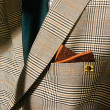 Load image into Gallery viewer, A men&#39;s burnt orange wool pocket square worn with a beige checked suit. The pocket square comes gift wrapped and is handmade by Daisy and Oak Studio.