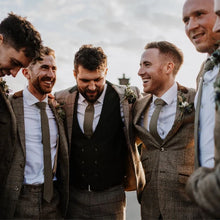 Load image into Gallery viewer, A photo of groomsmen wearing a sage green  cotton tie matched with a brown tweed suit. The tie is handmade by Daisy and Oak studio.