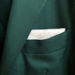 A cream wool pocket square matched with a wool bottle green mans suit by Daisy and Oak Studio.