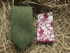 A moss green tie and red floral pocket square handmade by Daisy and Oak Studio, UK. The set comes with free gift wrapping and is perfect as a wedding tie and groomsmen gifts.