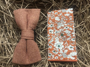 A camel brown bow tie and orange floral pocket square. The bow tie is made of wool and is pre-tied. The pocket square is cotton and has a white floral pattern on an orange background which works perfectly with the camel bow tie. All of our ties and pocket square are gift wrapped and make perfect mens Christmas gifts, secret Santa gifts and groomsmen gifts.